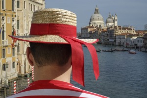 A gondolier surveys the Venice cityscape.