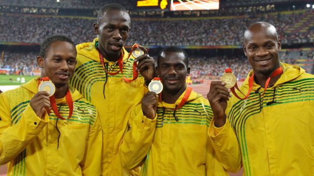 FILE - In this Saturday, Aug. 23, 2008 file photo, Jamaica's men's 4x100 meters relay team, from left, Michael Fraser, Usain Bolt, Nesta Carter and Asafa Powell show their gold medals during the athletics competitions in the National Stadium at the Beijing 2008 Olympics in Beijing. Usain Bolt has been stripped of one of his nine Olympic gold medals, Wednesday Jan. 25, 2017, in a doping case involving teammate Nesta Carter. (AP Photo/Petr David Josek, File)