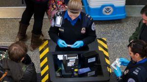 Transportation Security Administration (TSA) officers check passenger's identification at a security checkpoint at ...