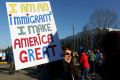 Ellen Furstner, 62, of Marcola, carries a sign during an immigrant rights rally at the Oregon State Capitol in Salem.