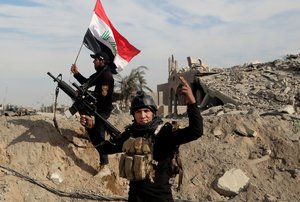 In this Sunday, Dec. 27, 2015 photo, Iraqi security forces raise an Iraqi flag near the provincial council building in central Ramadi, 70 miles (115 kilometers) west of Baghdad.