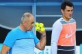 Bernard Tomic listens to his father and coach John Tomic during a practice session before the Australian Open 