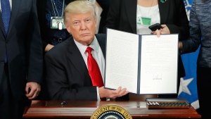 U.S. President Donald Trump holds up an executive order for border security and immigration enforcement improvements after signing the order during a visit to the Homeland Security Department headquarters in Washington, Wednesday, Jan. 25, 2017. (AP / Pablo Martinez Monsivais)