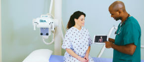 Doctor talking to a patient and holding a tablet