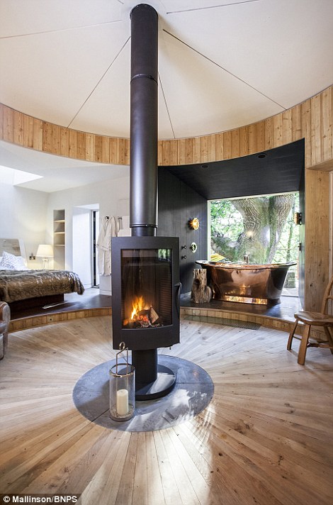 Inside there is a king sized bed , double-ended copper bath, kitchen, leather club chairs and a wood burner that stands in the centre of the circular room and rotates