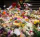 Two-year-old Jesse lays flowers at the tribute to the Bourke Street victims in Melbourne.