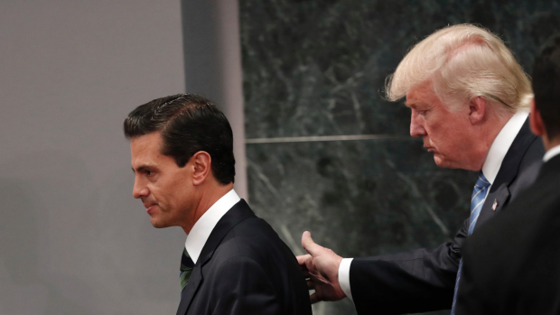 FILE - In this Aug. 31, 2016 file photo, Republican presidential nominee Donald Trump walks with Mexico President Enrique Pena Nieto at the end of their joint statement at Los Pinos, the presidential official residence, in Mexico City. Trump called his surprise visit to Mexico City a 'great honor.' A week later one of Nieto's closest advisers and confidants, Finance Secretary Luis Videgaray, resigned in a move seen as linked to the unpopular decision to invite Trump to visit Mexico. (AP Photo/Dario Lopez-Mills)