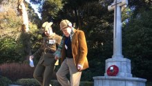 Jack Hopgood (right) is escorted down the steps from the Commonwealth War Cemetery