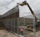 Workers raise a taller fence along the Mexico-US border between the towns of Anapra, Mexico and Sunland Park, New Mexico.