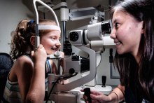 Charlotte Gardner has her eyes tested by a QUT optometry student.