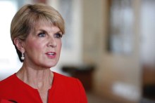 Foreign Minister Julie Bishop wears a red blazer and pearls to speak to the media.