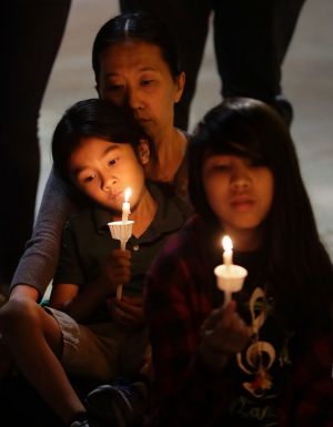 Yon Hui Bell holds her son, Emilio Rafael, as they join community activists in front of San Fernando Cathedral in San ...