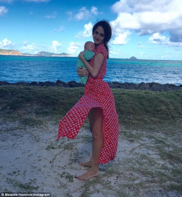 Sweet snap: Mick Jagger's partner Melanie Hamrick, 29, flaunted her slimmed down figure in a stylish dress as she cradled her newborn son Deveraux Octavian Basil while at the beach