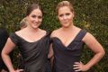 Schumer and sister Kim Caramele matched in similar Vivienne Westwood black gowns and hairstyles, which is probably ...