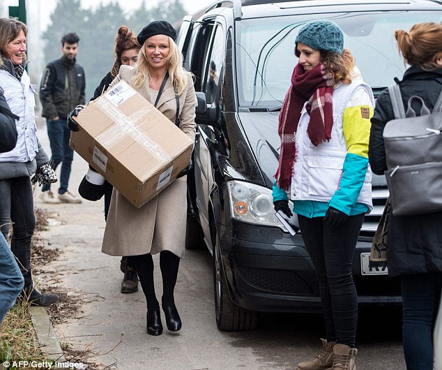 Bearing gifts: The star was seen carrying a large box of goods into the camp on her arrival 