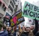 Demonstrators hold signs while marching towards Trump Tower during the Women's March in New York.