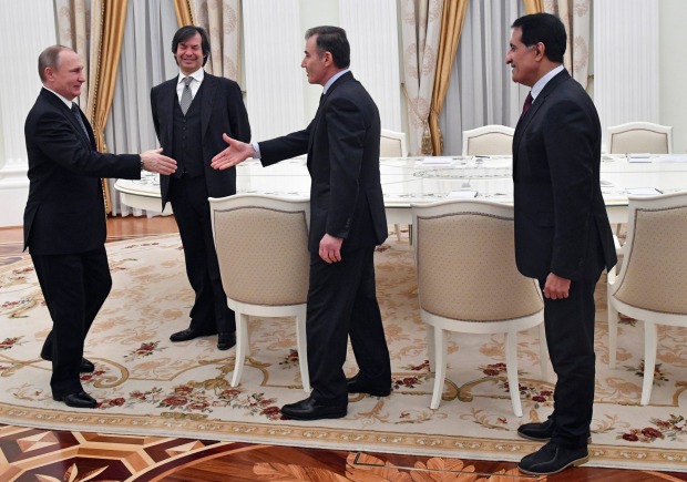 Russian President Vladimir Putin, left, shakes hands with Glencore CEO Ivan Glasenberg as CEO of the Qatar Investment ...