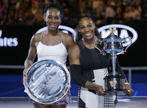 United States' Serena Williams, right, and her sister, Venus, hold their trophies after Serena won the women's singles final at the Australian Open tennis championships in Melbourne, Australia