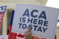 A demonstrator in support of US President Barack Obama's healthcare law, the Affordable Care Act after the US Supreme ...