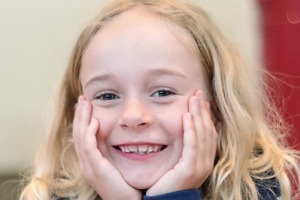 Seven-year-old Tara Doyle plays the ukulele outside her house to raise money for the Cancer Council ACT.