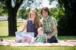 Katie and Josh Butler with their son Brax and a photo of their late son Dewey. 