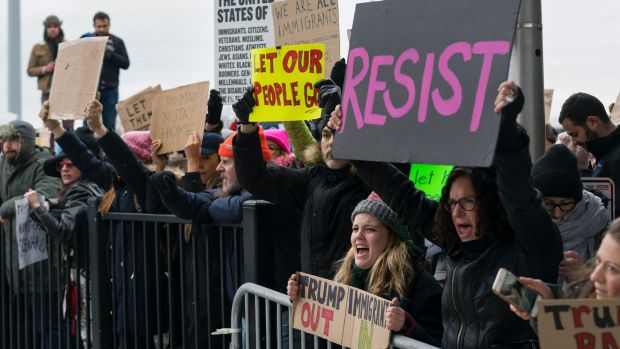 Protesters assemble at John F Kennedy International Airport in New York after two Iraqi refugees were detained while ...