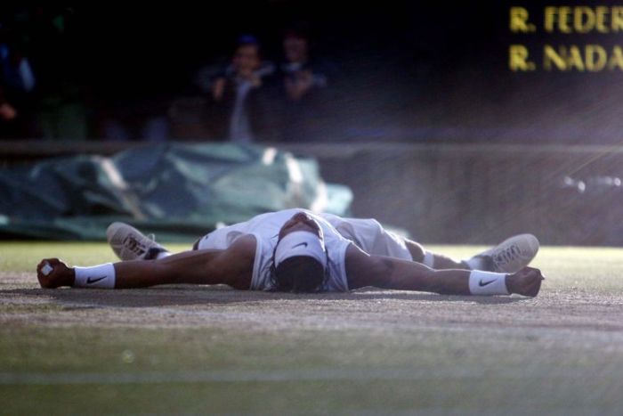 Rafael Nadal falls to the ground moments after winning the Wimbledon men's singles final