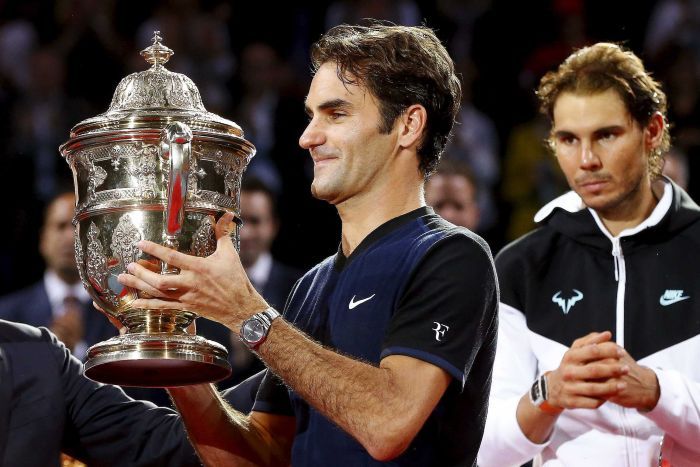 Roger Federer lifts the Basel trophy in front of Rafael Nadal