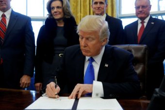 US President Donald Trump signs an executive order dealing with members of the administration lobbying foreign governments.