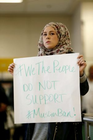 April Harrison-Bader protests President Donald Trump's executive action  at Dallas-Fort Worth Airport.