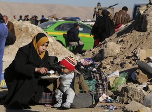 An Iraqi displaced mother, who fled fighting between Iraqi security forces and Islamic State militants, feeds her child in Bartella, around 19 miles (30 kilometers), from Mosul, Iraq, Friday, Jan. 6, 2017.