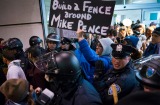 Protesters are surrounded by police officers and travellers as they pass through an exit of Terminal 4 at John F. ...