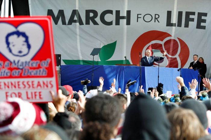 Mike Pence waves from the stage at a rally.