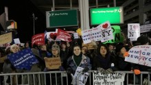 Protesters gather outside the JFK international terminal
