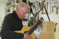 Ben Hall in his workshop fine tuning a guitar, one of his many creative talents.