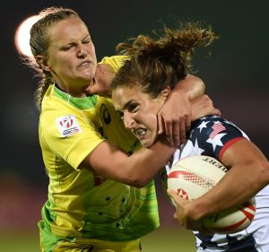 Crash tackle: Emma Sykes (left) brings down Ryan Carlyle of the US in Dubai.