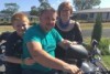 Bailey and his dad, Duncan, sit on a motorbike. 