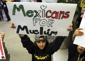 A young girl joins hundreds of people opposed to President Donald Trump's executive order barring entry to the U.S. by Muslims from certain countries as they demonstrate at the Tom Bradley International Terminal at Los Angeles International Airport Saturday, Jan. 28, 2017.