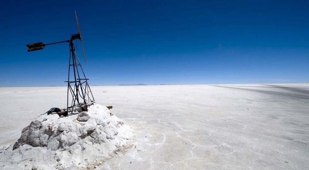 A tourist walks near the steam let off from fumaroles at the Uyuni salt flats, Bolivia.