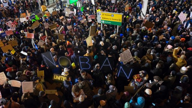 Protesters assemble at John F. Kennedy International Airport in New York after  two Iraqi refugees were detained while ...