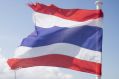 A tourist stands next to a Thai national flag while travelling on a ferry near Koh Phangan, Surat Thani, Thailand, on ...