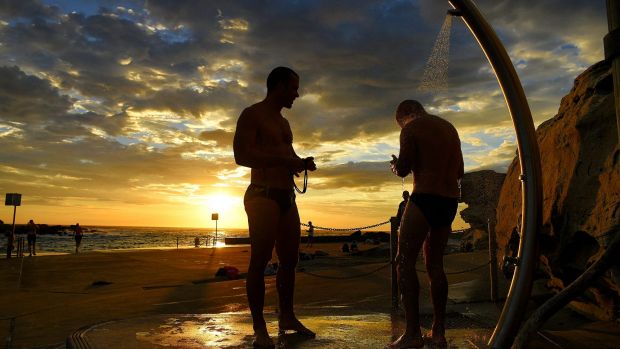 Swimmers rinse off at Clovelly Beach before the temperatures rise in Sydney on Tuesday morning.