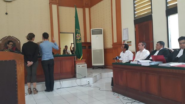 Sara Connor taking an oath before testifying as David Taylor watches on at Denpasar District Court on Monday.