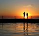 A couple take in the sunrise at Cronulla Rock pool.