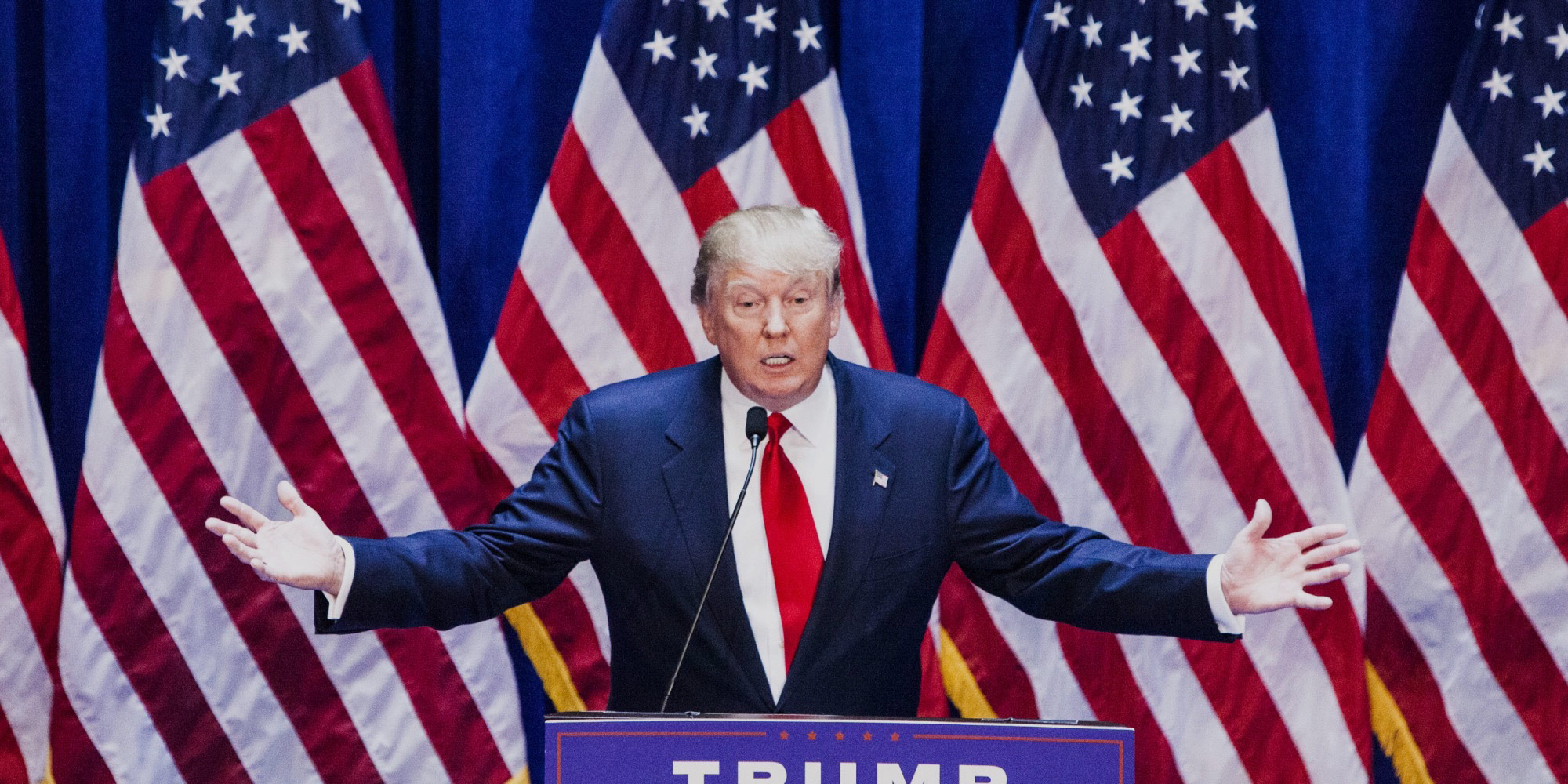 Trump in front of many US flags