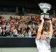 Man of the people: Roger Federer presents the trophy to fans on Margaret Court Arena.