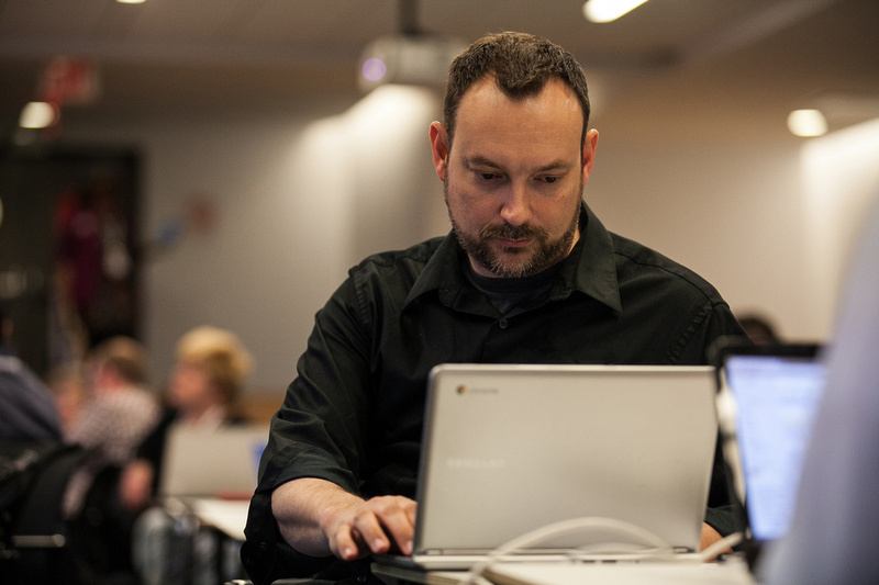 A teacher works on his laptop