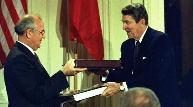 Then US President Ronald Reagan and Soviet leader Mikhail Gorbachev exchange copies of a treaty to eliminate ...