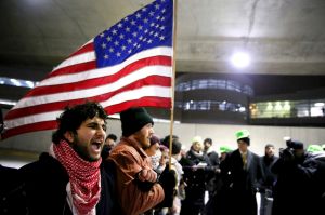 Protesters gather at O'Hare International Airport after people were detained, including green card holders, Saturday, ...