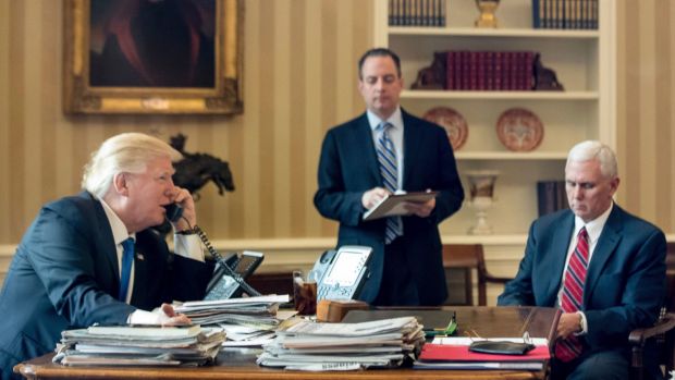 President Donald Trump, accompanied by Chief of Staff Reince Priebus and Vice-President Mike Pence, speaks on the phone ...